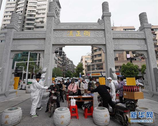  4月16日，進(jìn)出武漢漢正街步行街的人員在掃描健康碼。新華社記者 王毓國(guó) 攝